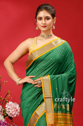 a woman in a green and gold sari