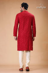 a man in a red sherwa with white pants