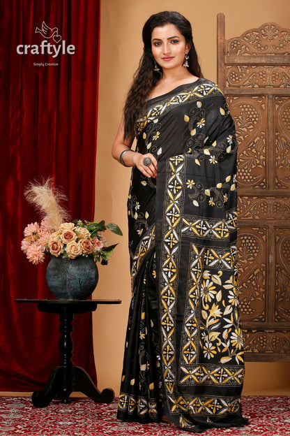 a woman in a black and gold sari