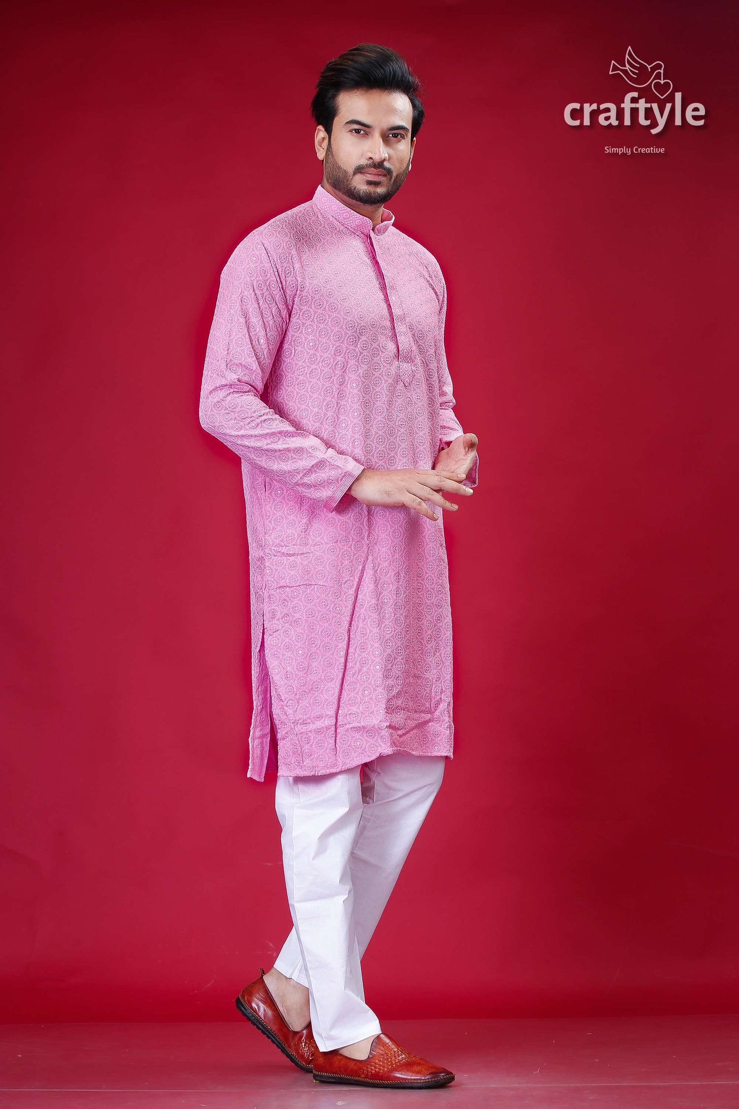 a man in a pink shirt and white pants