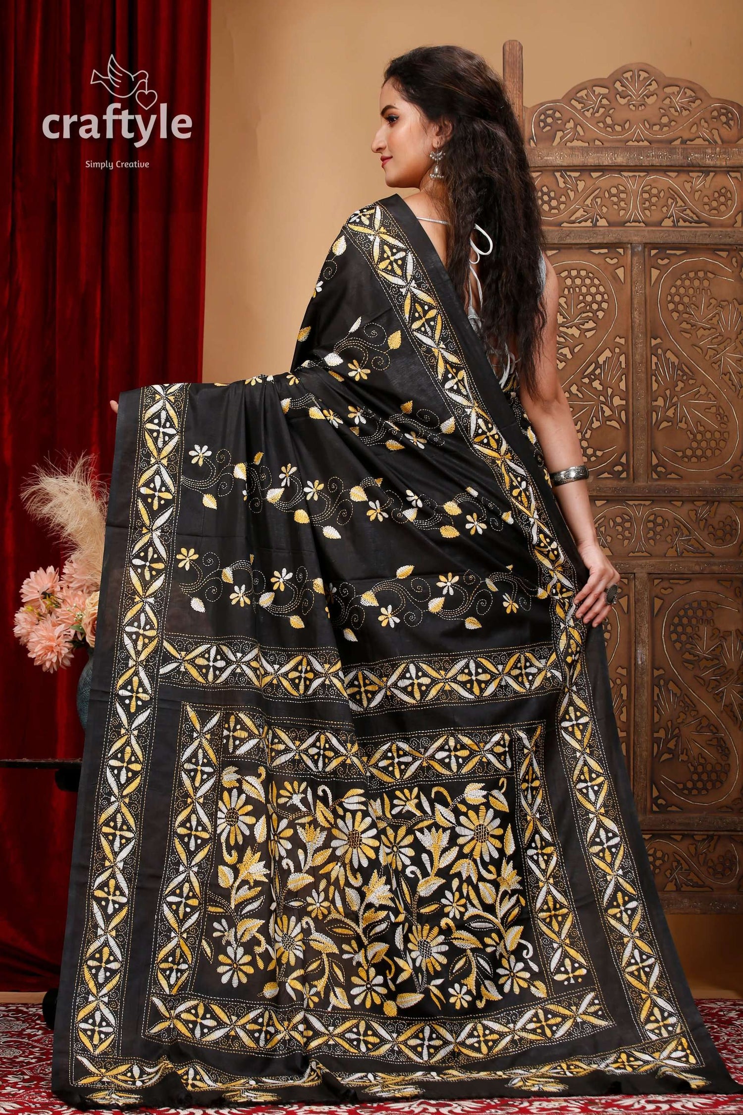 a woman in a black and gold sari