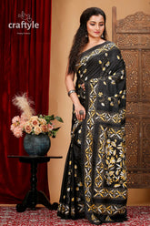 a woman in a black and gold sari