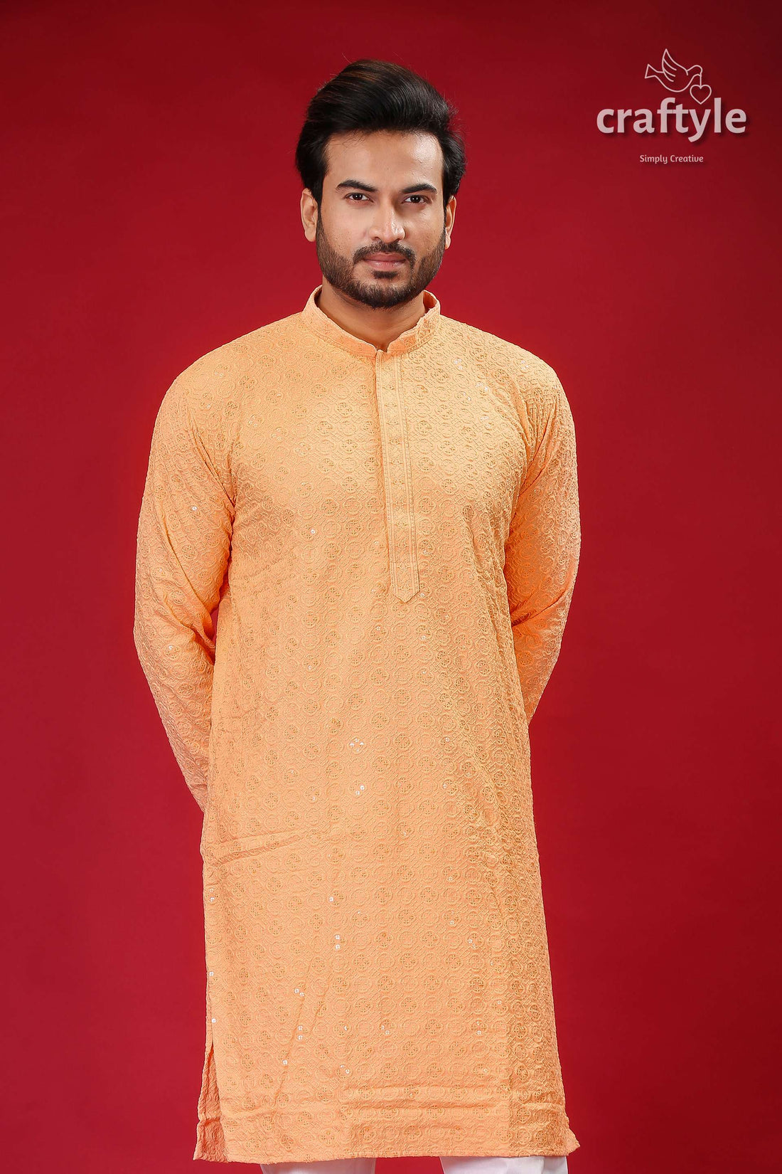 a man in an orange outfit standing in front of a red background