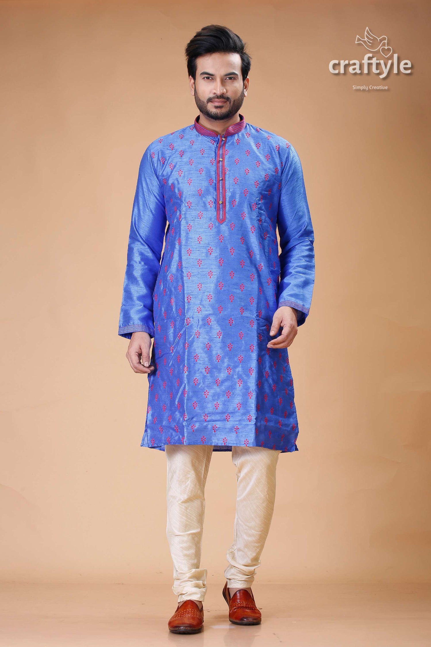 a man in a blue and pink indian outfit