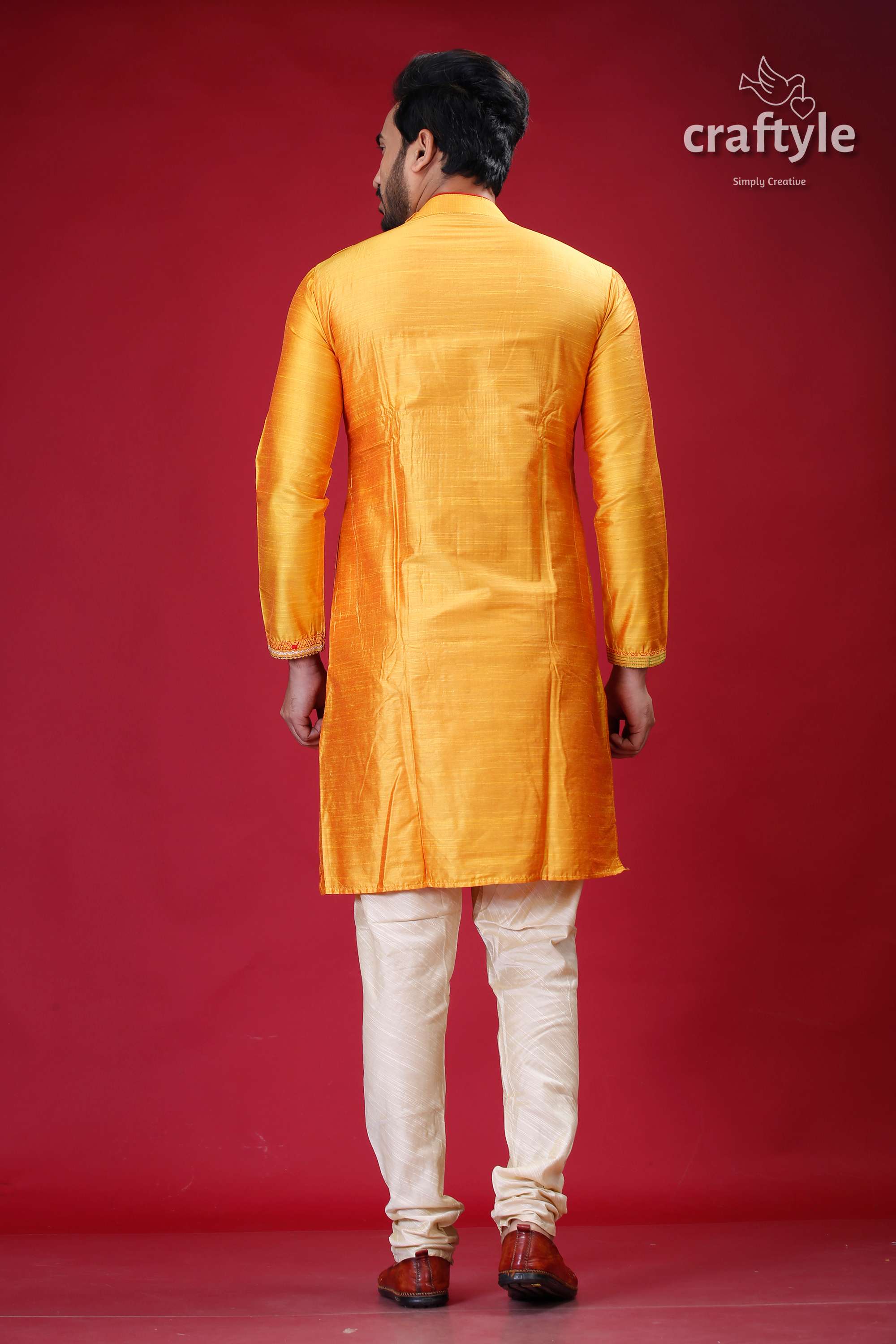 a man in a yellow sherwa with white pants