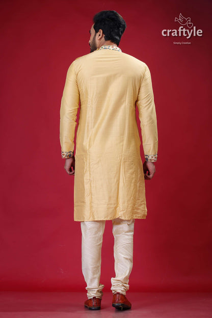 a man in a yellow sherwa with white pants