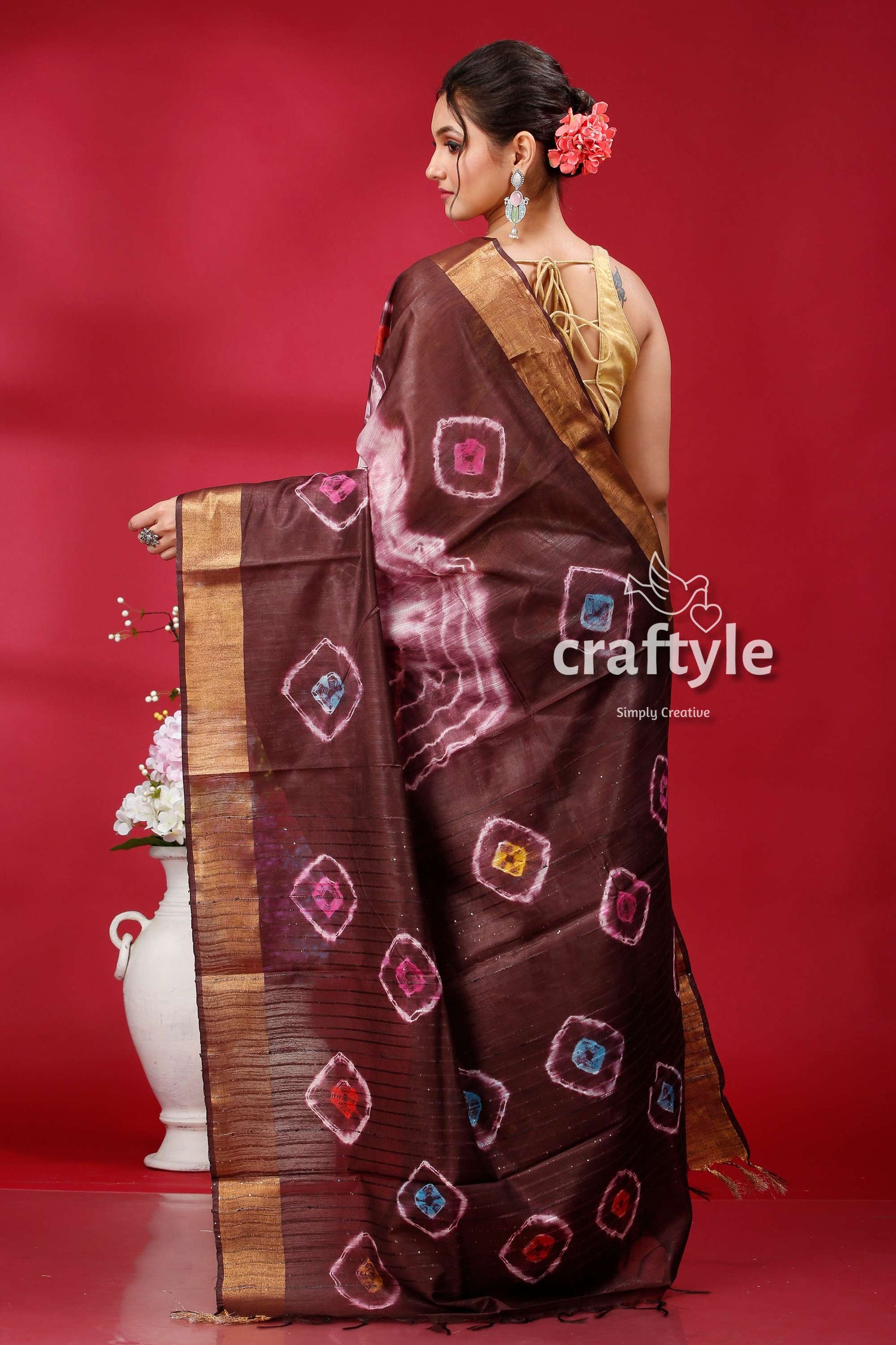 a woman in a brown and pink sari